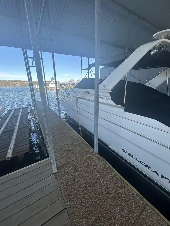 Slide: The Image of 1997 Wellcraft 3600 Martinique yacht docked at a marina under a covered slip. - 1