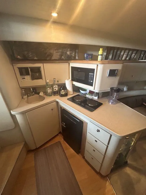 Slide: The Image of 1997 Wellcraft 3600 Martinique yacht kitchen with microwave, sink, and stove. - 15