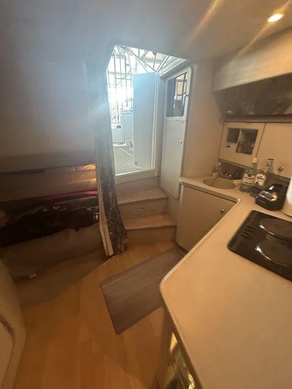 Slide: The Image of Interior of 1997 Wellcraft 3600 Martinique yacht, featuring kitchen and sleeping area. - 16