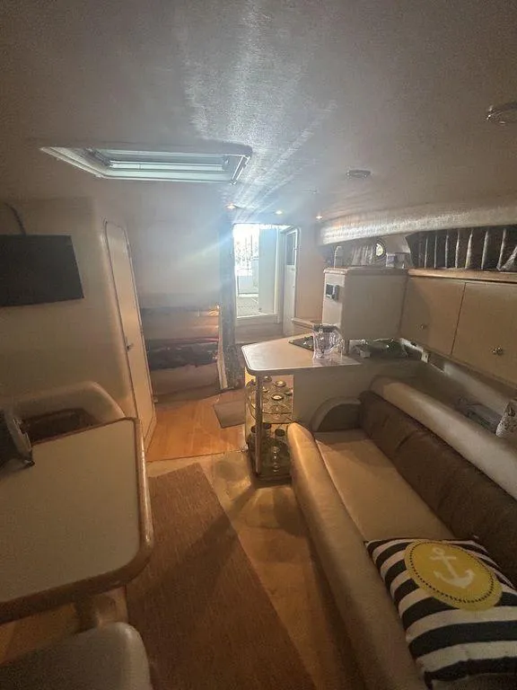 Slide: The Image of 1997 Wellcraft 3600 Martinique interior cabin with seating, table, and kitchenette. - 20
