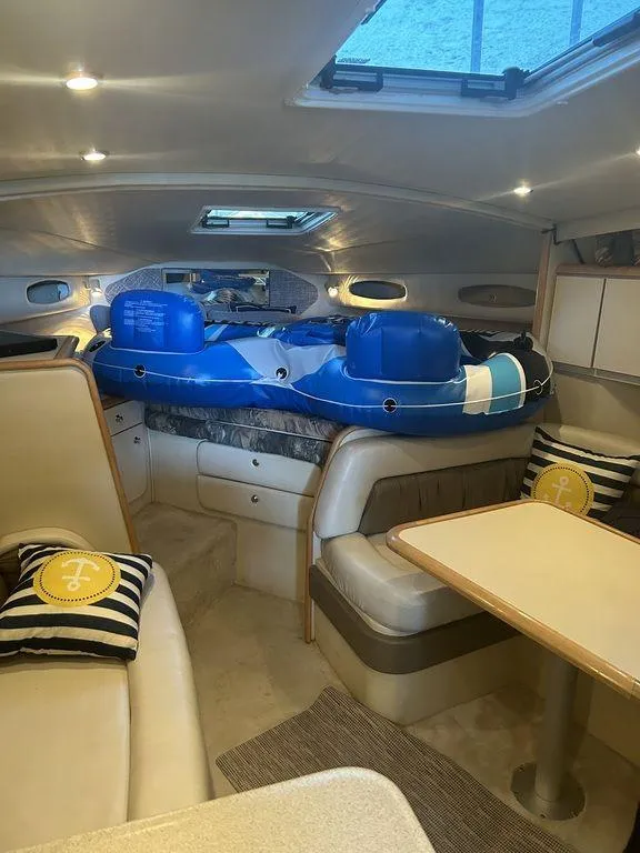 Slide: The Image of 1997 Wellcraft 3600 Martinique cabin interior with seating, table, and inflatable water toys. - 28