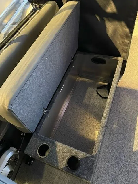 Slide: The Image of 2024 Spartan 185 Astoria boat storage compartment with cushioned seat and cup holders. - 5