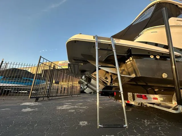 Slide: The Image of 2023 Regal 36 Grande Coupe boat with ladder, parked on pavement near a fence. - 15