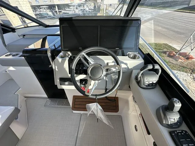 Slide: The Image of 2023 Regal 36 Grande Coupe helm with modern steering and navigation controls. - 18