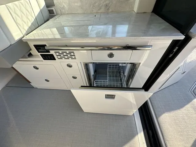 Slide: The Image of 2023 Regal 36 Grande Coupe interior with open fridge and modern cabinetry. - 24