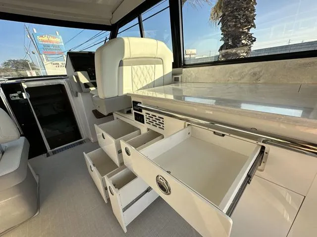Slide: The Image of 2023 Regal 36 Grande Coupe interior with open storage drawers and luxurious seating. - 25
