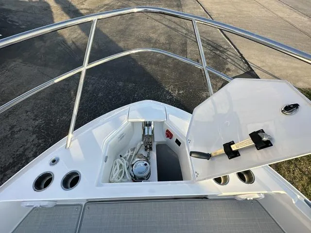 Slide: The Image of 2023 Regal 36 Grande Coupe bow with open storage compartment and railing. - 33