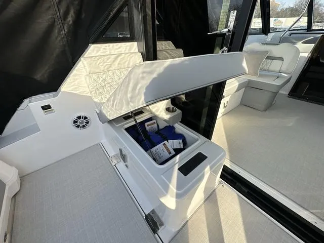 Slide: The Image of 2023 Regal 36 Grande Coupe interior with open storage compartment and seating area. - 38