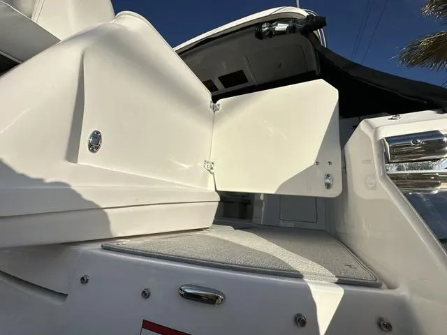 Slide: The Image of 2023 Regal 36 Grande Coupe boat with open storage compartment, sleek white design. - 43