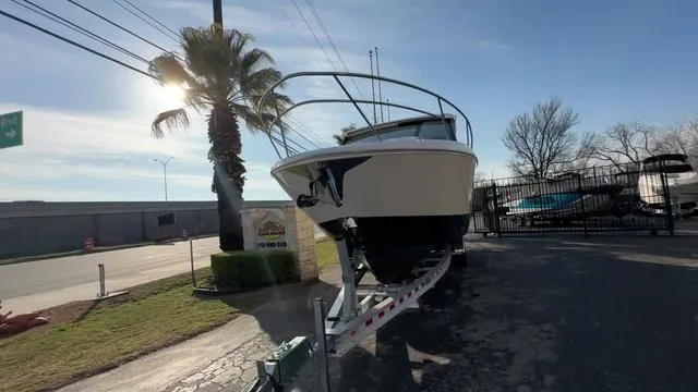 Slide: The Image of 2023 Regal 36 Grande Coupe boat on trailer, sunny day, palm tree nearby. - 6