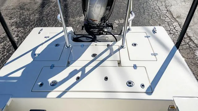 Slide: The Image of 2024 Hewes 16 Redfisher boat deck with storage compartments and outboard motor. - 12