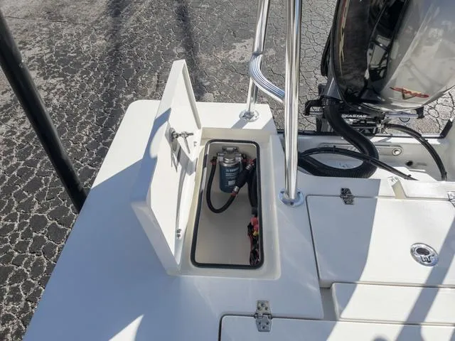 Slide: The Image of 2024 Hewes 16 Redfisher boat with open storage compartment and motor. - 16