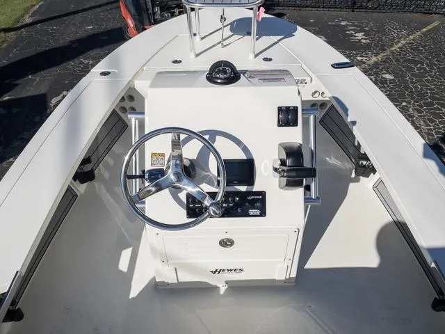 Slide: The Image of 2024 Hewes 16 Redfisher boat console with steering wheel and controls. - 17