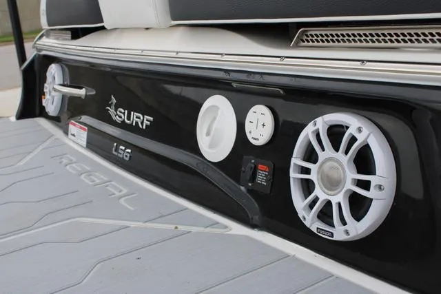 Slide: The Image of 2024 Regal LS6 Surf boat with speakers and control panel on deck. - 10