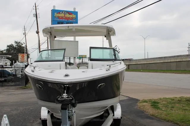 Slide: The Image of 2024 Regal LS6 Surf boat on trailer at dealership, front view. - 14