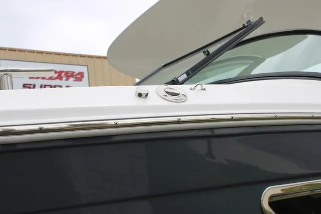 Slide: The Image of 2024 Regal LS6 Surf boat exterior detail with windshield and sleek design. - 18