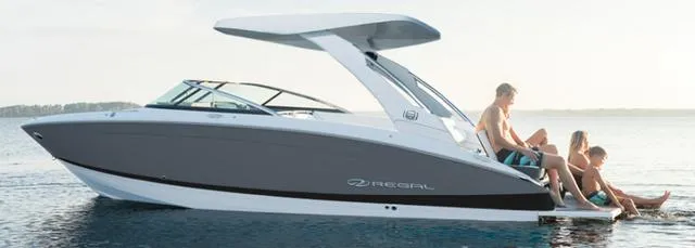 Slide: The Image of 2024 Regal LS6 Surf boat with people relaxing on the water. - 2