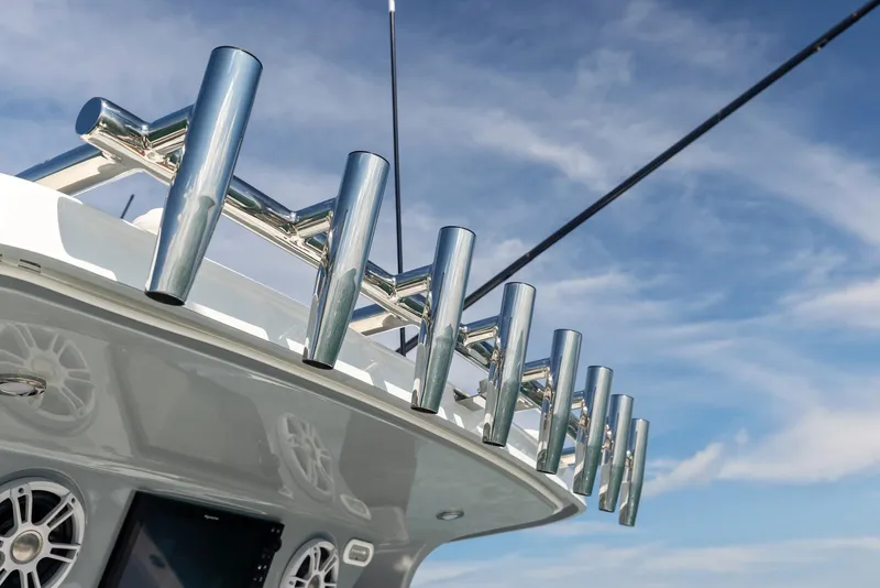 Slide: The Image of Aquila 47 Molokai 2024 boat with rod holders and speakers against blue sky. - 19