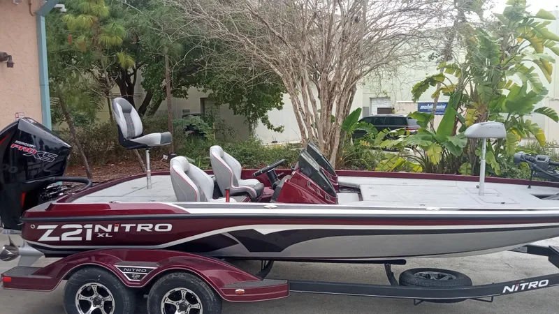 Slide: The Image of 2024 Nitro Z21 XL Pro bass boat with trailer, parked outdoors. - 0