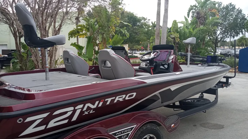 Slide: The Image of 2024 Nitro Z21 XL Pro bass boat in maroon, parked outdoors. - 1
