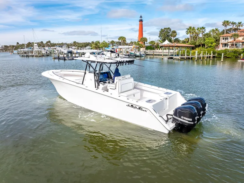 Slide: The Image of 2020 SeaHunter 35 Tournament boat cruising near a lighthouse and marina. - 12