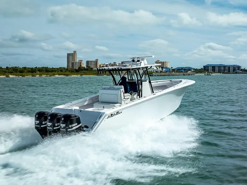 Slide: The Image of 2020 SeaHunter 35 Tournament boat cruising on water with triple Yamaha engines. - 13