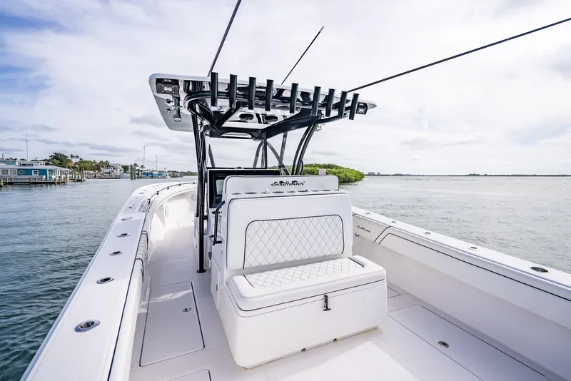 Slide: The Image of 2020 SeaHunter 35 Tournament boat with white seating and rod holders on a calm waterway. - 47