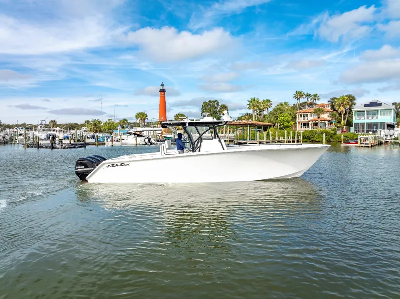 Slide: The Image of 2020 SeaHunter 35 Tournament boat cruising in a scenic marina with a lighthouse. - 6