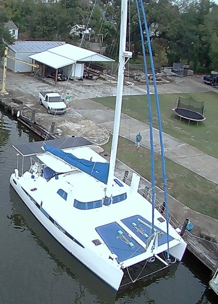 Slide: The Image of Aerial view of a 2002 Dolphin 43 catamaran docked near a waterfront property. - 15