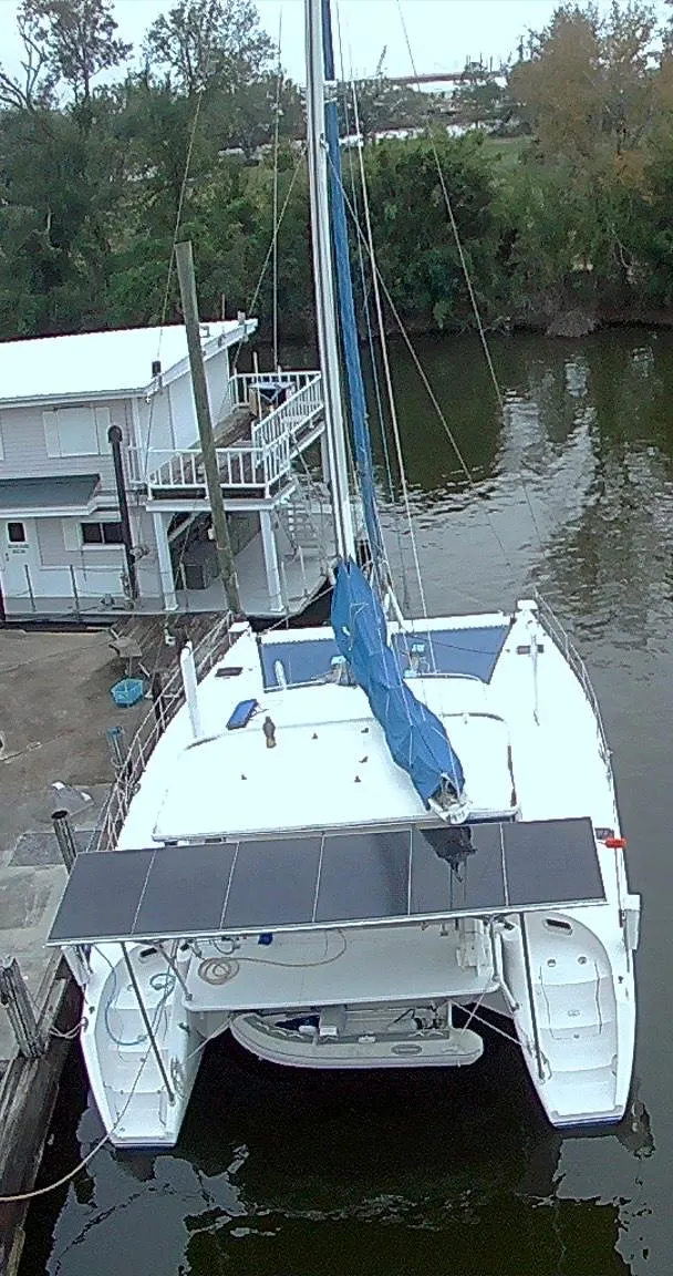Slide: The Image of Aerial view of a 2002 Dolphin 43 catamaran docked by a riverside. - 17