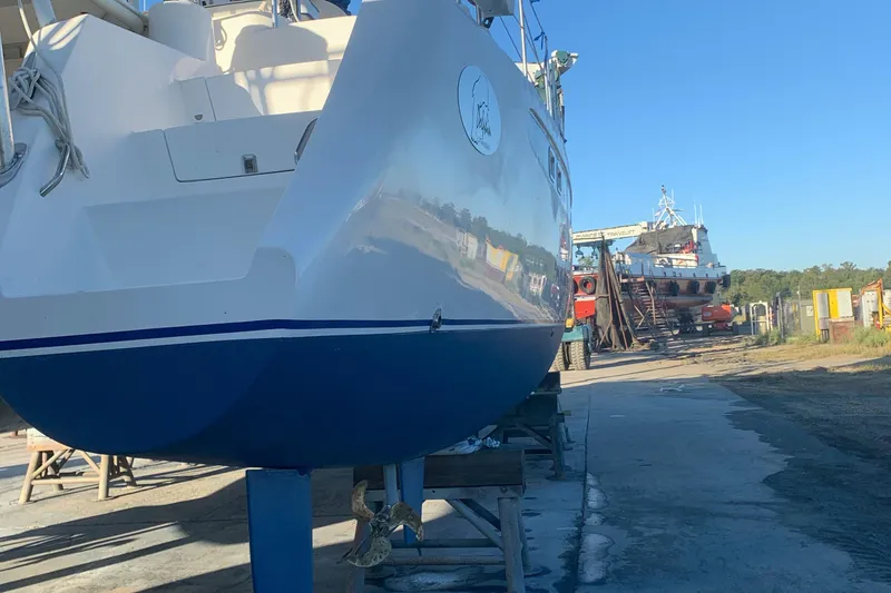 Slide: The Image of Dolphin 43 sailboat from 2002 on dry dock, with clear blue sky background. - 20