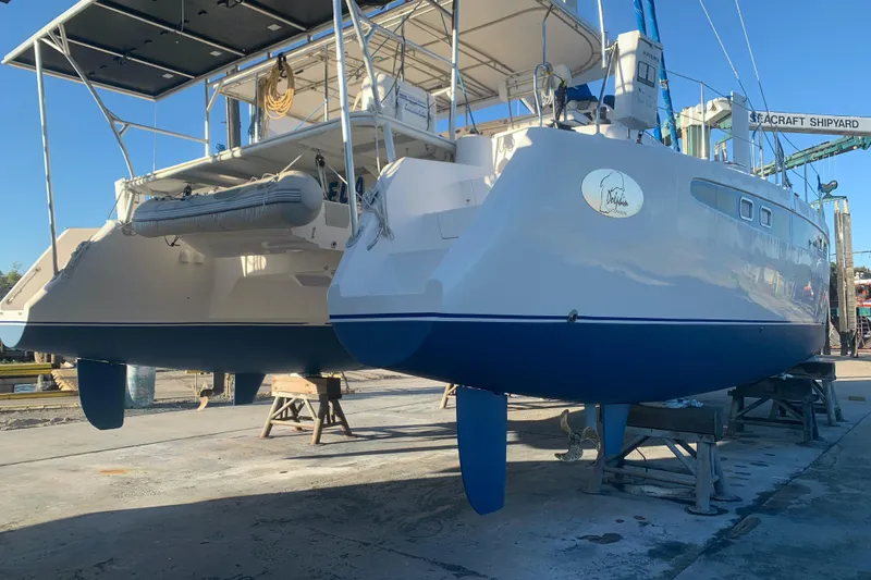 Slide: The Image of Catamaran Dolphin 43, 2002 model, docked at a shipyard for maintenance. - 24