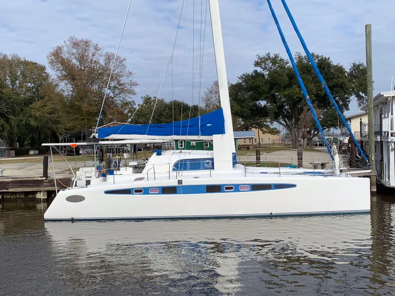 Slide: The Image of Sailing catamaran Dolphin 43, 2002 model, docked by trees and buildings. - 26