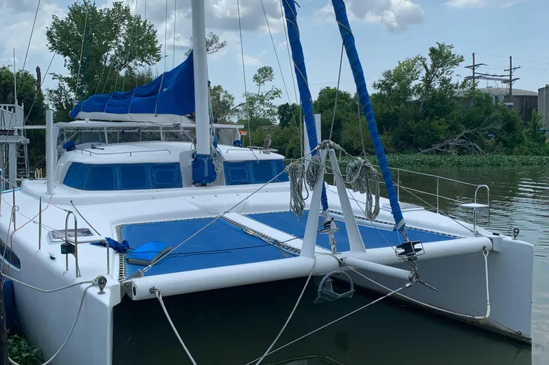 Slide: The Image of Sailing catamaran Dolphin 43, 2002 model, docked on a calm river. - 28