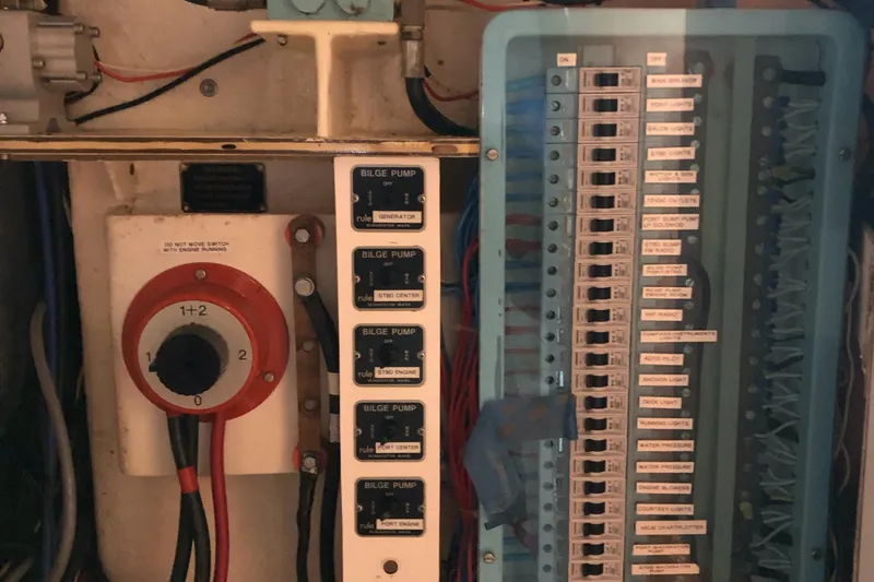 Slide: The Image of Electrical panel with switches and circuit breakers in a 2002 Dolphin 43 boat. - 34