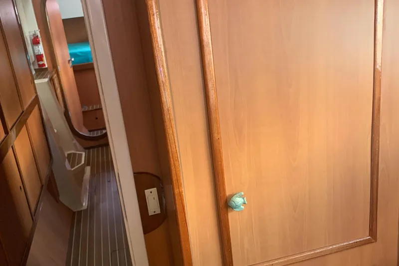 Slide: The Image of Interior of 2002 Dolphin 43 yacht with wooden paneling and hallway view. - 37