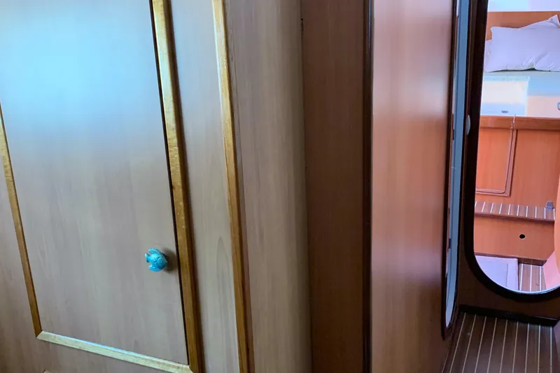 Slide: The Image of Interior view of 2002 Dolphin 43 yacht, featuring wooden cabinetry and a cozy cabin space. - 41