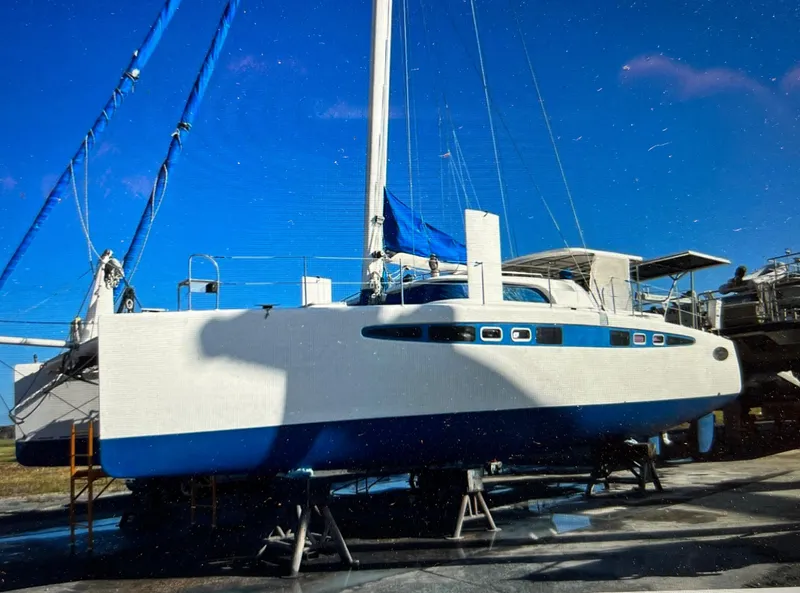 Slide: The Image of Sailboat Dolphin 43, 2002 model, on dry dock under clear blue sky. - 6