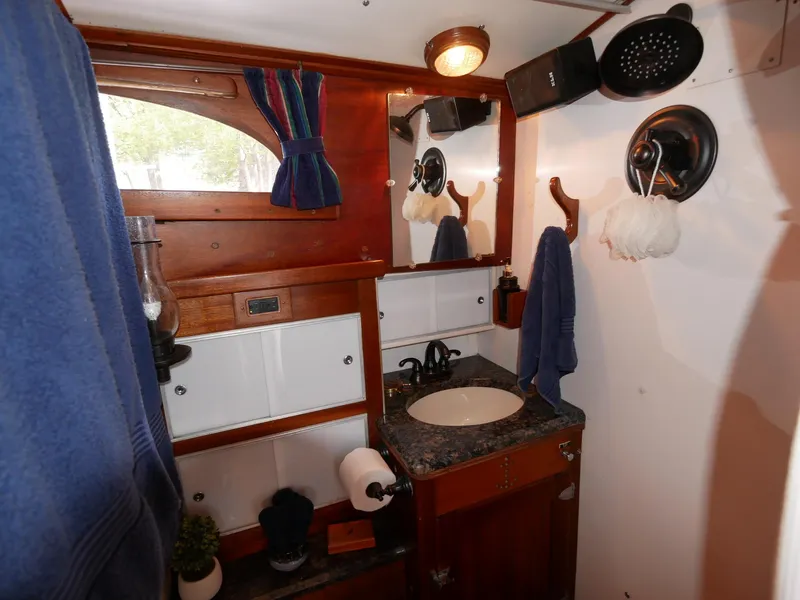 Slide: The Image of 1964 Egg Harbor 37 Convertible Sedan bathroom with wooden cabinetry and nautical decor. - 24