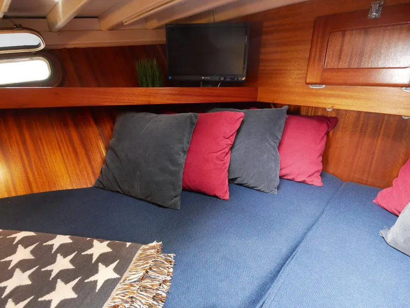 Slide: The Image of Cozy cabin interior of 1964 Egg Harbor 37 Convertible Sedan with pillows and TV. - 19