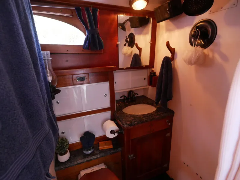 Slide: The Image of 1964 Egg Harbor 37 Convertible Sedan bathroom with wooden cabinetry and nautical decor. - 23