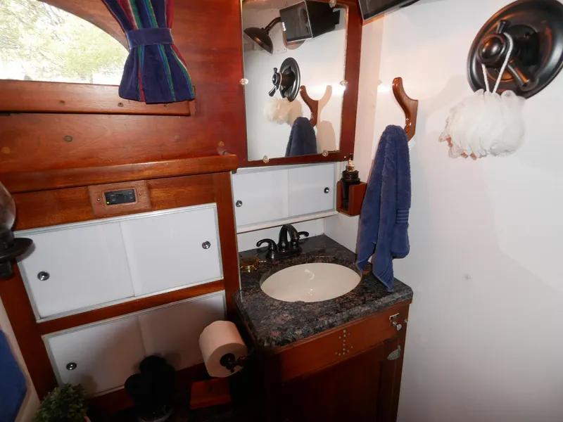 Slide: The Image of 1964 Egg Harbor 37 Convertible Sedan bathroom with wooden cabinetry and granite countertop. - 26