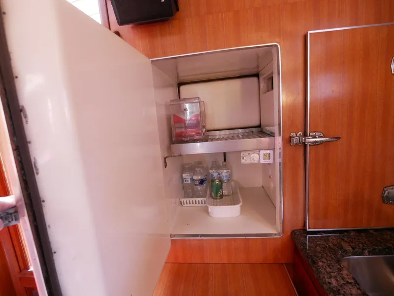 Slide: The Image of 1964 Egg Harbor 37 Convertible Sedan refrigerator with open door, showing interior storage. - 31