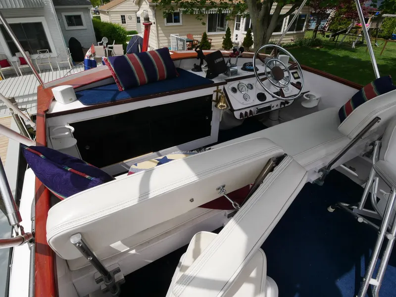 Slide: The Image of 1964 Egg Harbor 37 Convertible Sedan boat interior with white seating and striped cushions. - 42