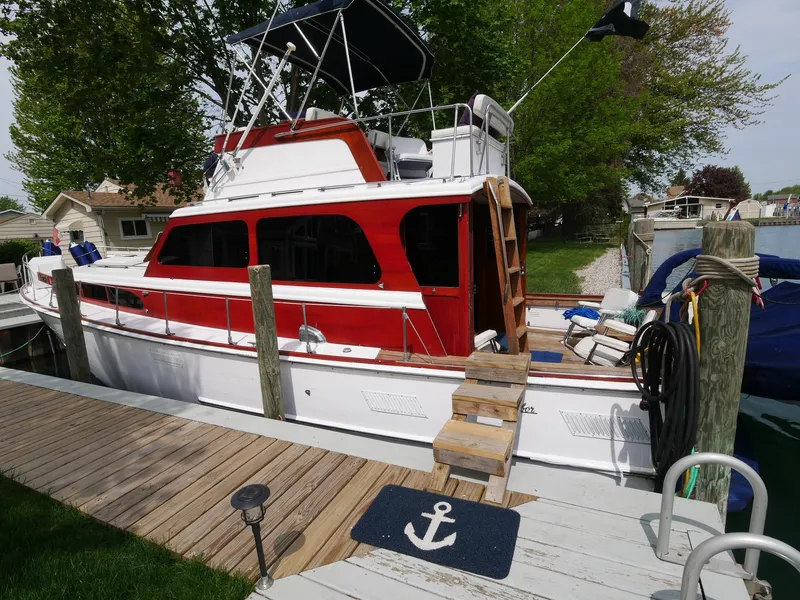 Slide: The Image of 1964 Egg Harbor 37 Convertible Sedan docked at a marina with wooden steps and anchor mat. - 44