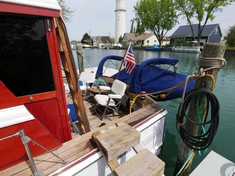 Slide: The Image of 1964 Egg Harbor 37 Convertible Sedan docked with American flag and waterfront homes in background. - 45