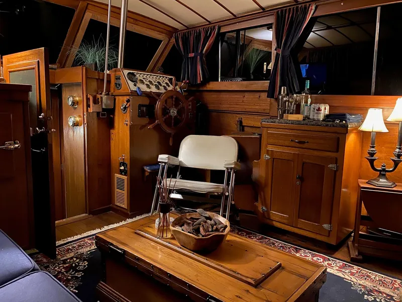 Slide: The Image of 1964 Egg Harbor 37 Convertible Sedan interior with wooden helm, vintage decor, and nautical furnishings. - 48