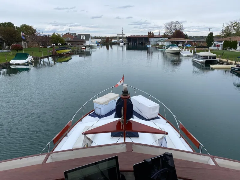 Slide: The Image of View from the bow of a 1964 Egg Harbor 37 Convertible Sedan cruising through a calm canal. - 5