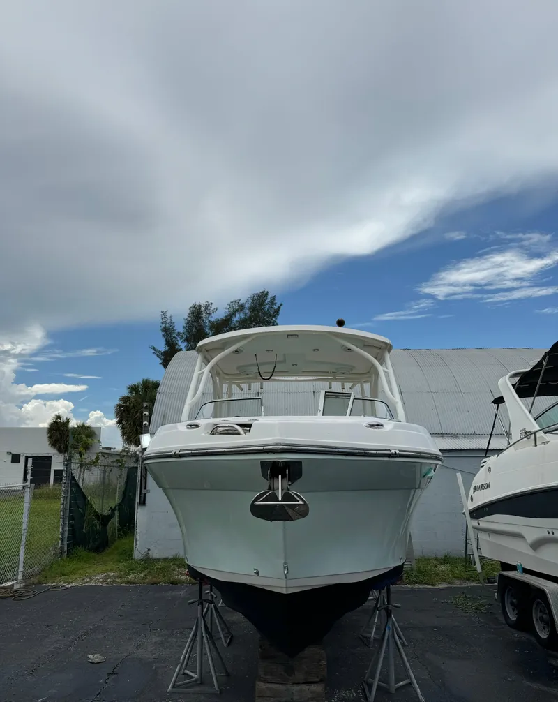Slide: The Image of 2017 Century 24 Resorter boat on stands, under a cloudy sky. - 2