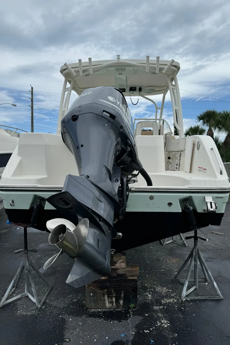 Slide: The Image of 2017 Century 24 Resorter boat with outboard motor, displayed on stands under cloudy sky. - 3